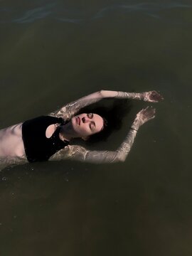 Serene Woman Floating in Dark Water