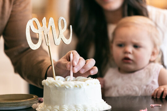 Father Puts One Candle In Birthday Cake