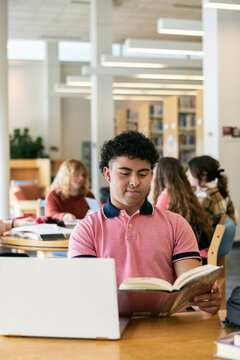 Male Student Reading Library Book