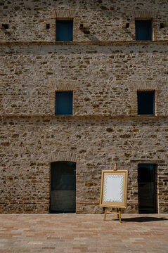 Artisan frame stands against a rustic stone wall