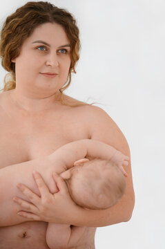 Topless plus size woman breastfeeding baby on white background