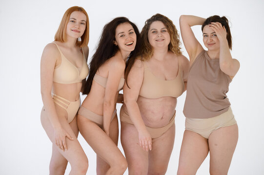 Group of diverse laughing women posing in the studio