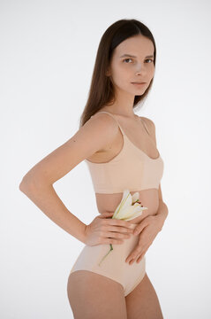 portrait of a skinny woman with flower on a white background
