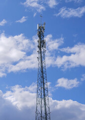 Obraz premium Tall Steel Lattice Telecommunications Mast with Antenna Arrays Against Blue Sky — Mobile Network 5G Infrastructure and Wireless Communication Concept
