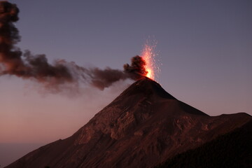 erupting volcano Fuego in Guatemala with lava and smoke during twilight, dawn © Janette Emerich
