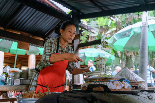Woman cooking a Thai Sukothai heritage dish Khao Perb