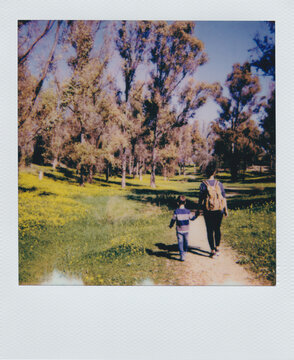 Polaroid photo of woman and child walking in forest