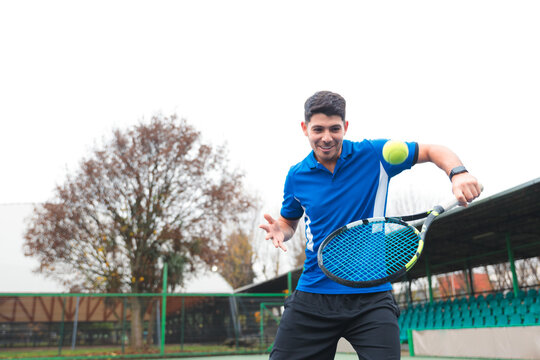 Smiling Tennis Player Practicing Ball Control on Court