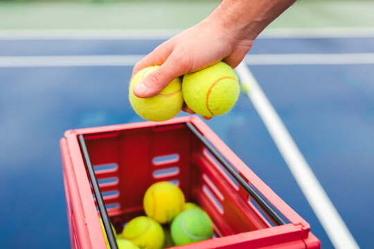 Hand Reaching for Tennis Balls from Training Basket