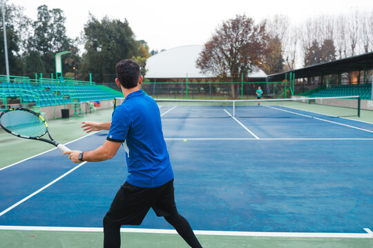 Male Tennis Player Executing Forehand Shot During Match