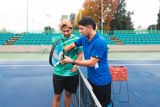 Male Coach Explains Grip Techniques in Tennis Practice