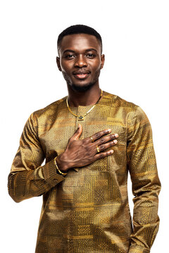 Confident young Black man with hand over heart wearing elegant gold patterned shirt