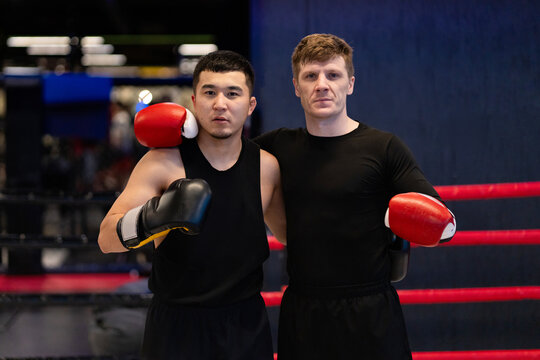 Two Male Boxers with Gloves Posing Together in Boxing Ring