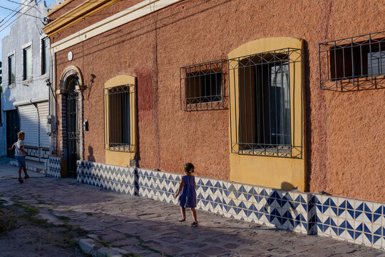 Children running on the sidewalk in La Paz, MX