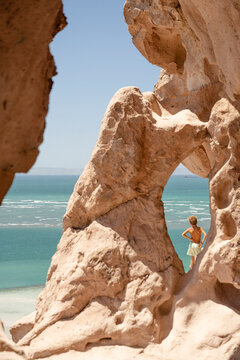 boy looking out to sea under sandstone arches