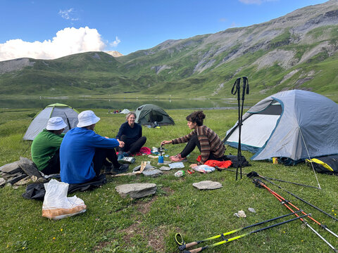 UGC group of hikers sitting down for snack while setting up camp. 