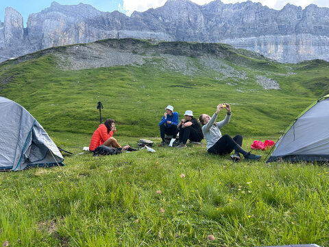UGC group of hikers sitting down for snack while setting up camp. 