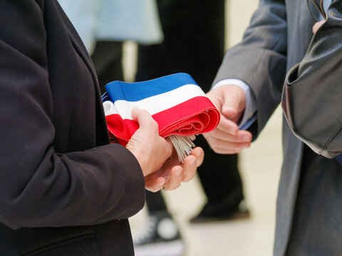 Remise de l&rsquo;&eacute;charpe tricolore entre officiels lors d&rsquo;une c&eacute;r&eacute;monie en mairie