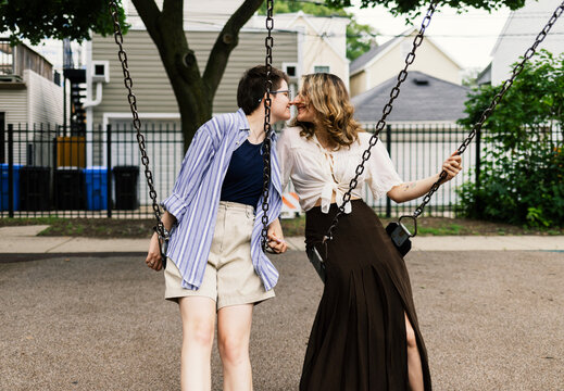 Couple on Swings about to Kiss