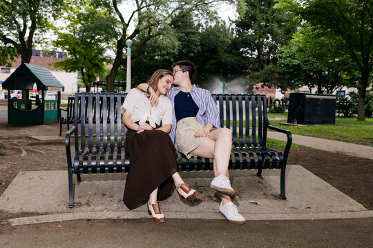 Lesbian couple sharing moment on park bench