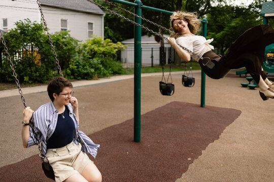 Two women laughing while swinging