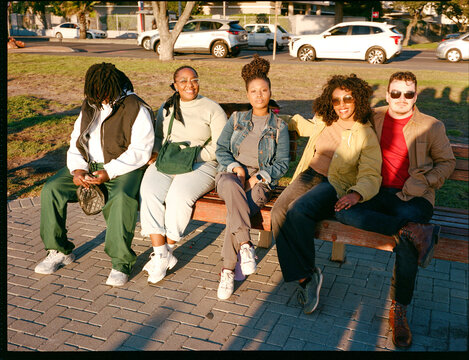 Group of friends sitting on a bench at sunset
