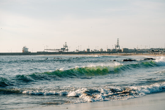 Waves Gently Roll Onto Shore at a Coastal Port During Sunset