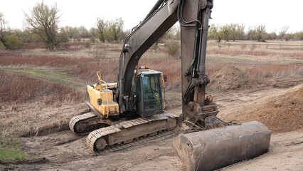 Nowoczesny park maszynowy na placu budowy: potężne koparki gąsienicowe gotowe do intensywnych prac ziemnych i przygotowania terenu pod nową infrastrukturę w pełnym słońcu na surowym tle © tomo81