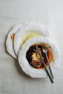 Stacked Plates with Partially Eaten Gourmet Meal