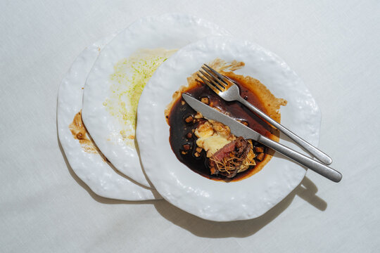 Stacked Plates with Partially Eaten Gourmet Meal