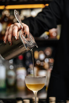 Bartender Pouring Cocktail into a Chilled Glass 