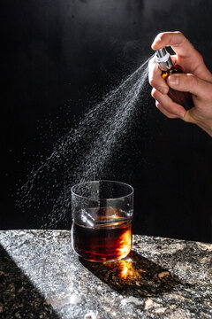 Spraying aroma over whiskey cocktail 