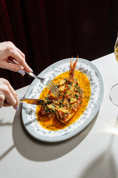 Grilled fish with herbs and sauce on decorative plate