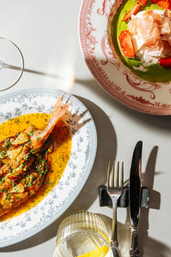Gourmet seafood and prosciutto salad served on decorative plates