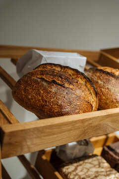 Crusty artisan sourdough bread on wooden shelf