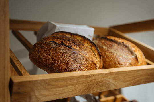 Fresh crusty sourdough bread on wooden shelf