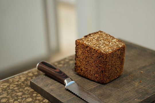 Whole grain rye bread on cutting board with knife