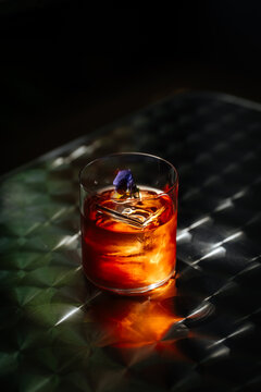 Negroni cocktail with ice and flower garnish in glass