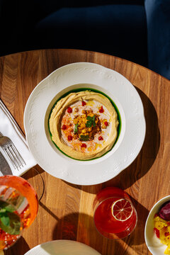 Hummus with garnish served on wooden table