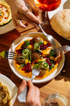 Falafel with hummus and vegetables shared at table