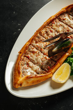 Close-up of Turkish pide with minced meat and melted cheese