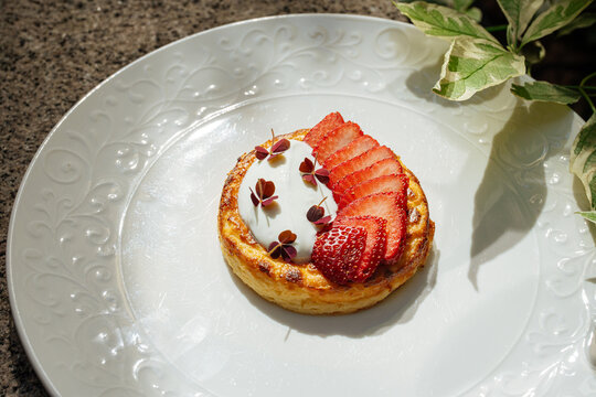 Strawberry cheesecake tart with cream and microgreens