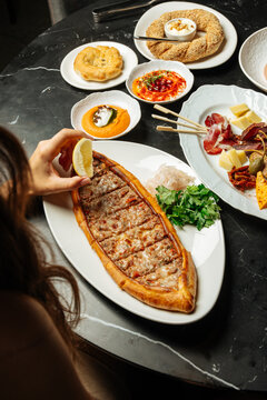 Turkish pide with meat and cheese served with appetizers