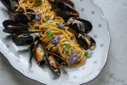 Mussel spaghetti with creamy sauce and herbs