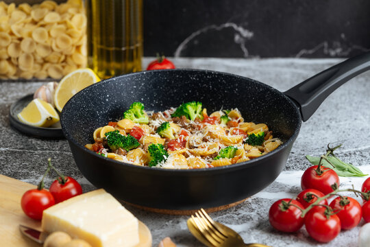 Orecchiette pasta with broccoli, ground meat, tomato, and cheese in a 