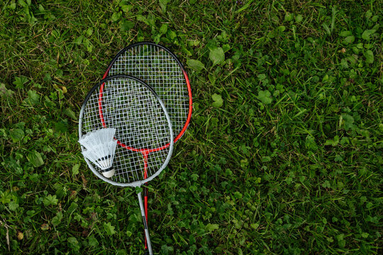 Badminton rackets and shuttlecock on grass