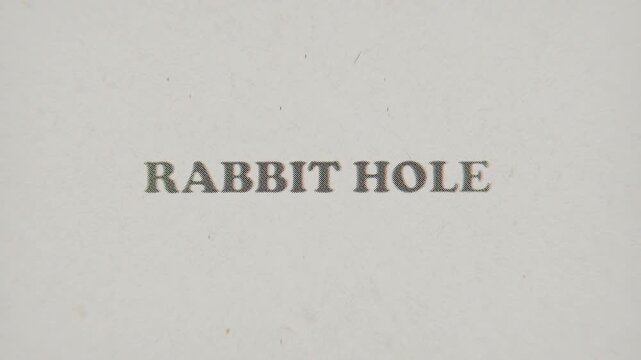 CMYK Halftone Text Rabbit Hole Printed on Changing Paper with Vintage Stop Motion Effect.