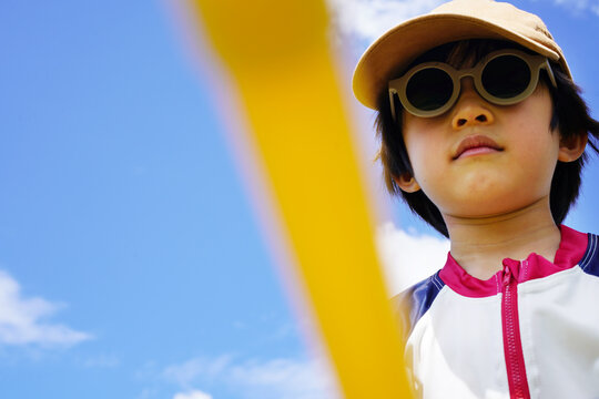 Portrait of a playful Chinese boy under a blue summer sky