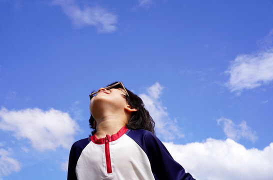 Portrait of a playful Chinese boy under a blue summer sky
