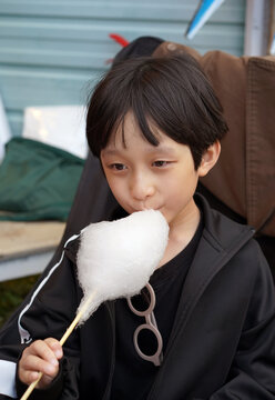 Close-up of a Chinese boy eating cotton candy